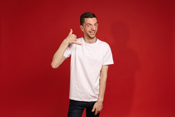 A young man in a white T-shirt gestures to the bell