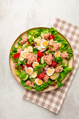 Tuna salad, vegetable salad with quail eggs, lettuce, red onion and cucumbers, on a light gray table, keto food, lifestyle, healthy eating, selective focus, top view, no people,
