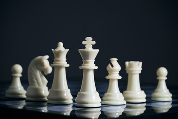 All suits white chess pieces on chess board.