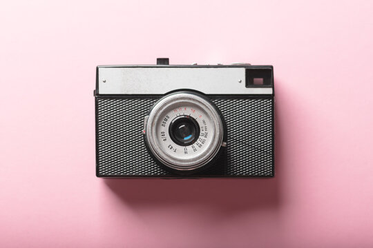 Old film retro camera on pink background. Photography concept