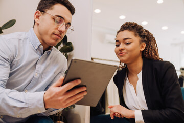 Multiracial man and woman in uniform working in clothes store