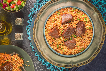 Arabic Cuisine: Orzo stew topped with meat chunks. Top view with close up.