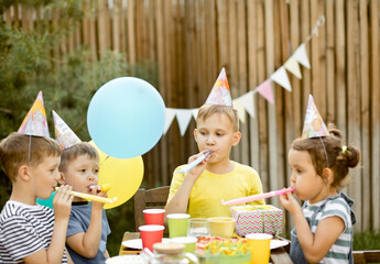 Cute funny nine year old boy celebrating his birthday with family or friends with homemade baked...