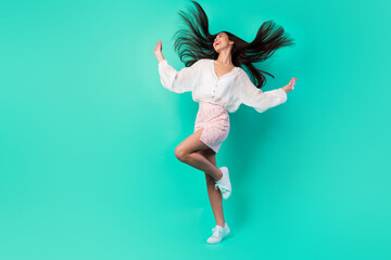 Full size photo of cheerful overjoyed filipino lady throw black hairdo enjoy dancing isolated on cyan color background