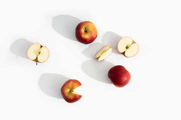 Whole, halves and cut apples on a white background. Top view, flat lay