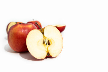 Whole and cut red fresh apples on white background, side view