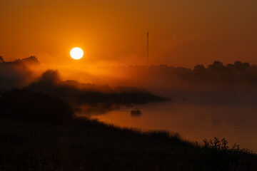 Beautiful and amazing sunrise over the river in fog