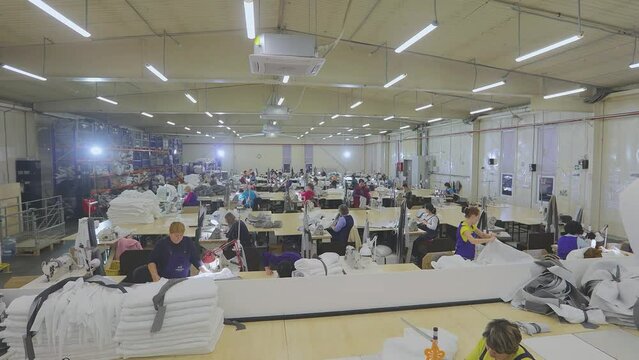 Many seamstresses work in the factory. Sewing shop time lapse. Work in a large sewing shop time lapse. Sewing factory from the inside
