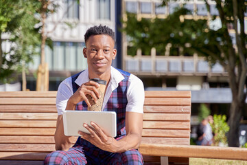 Fototapeta premium african american young man with tablet computer and take away coffee