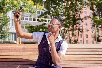 young african american man using his smart phone to take a selfie or make a video call