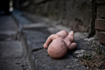 Nackte Puppe liegt am Straßenrad