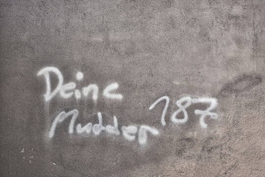 Jugendlicher Ausdruck und Schriftzug "Deine Mudder"