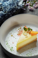 New York cheesecake or classic cheesecake with fresh berries on white plate, wooden table background and copy space for text