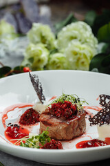 Appetizing beef in sweet sauce close up. Chopped beef meat in cherry sauce with vegetables on plate. Delicious european cuisine