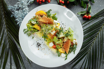 Summer diet salad with leaves of lettuce, watermelon, peach and feta cheese. On a light blue background copy space