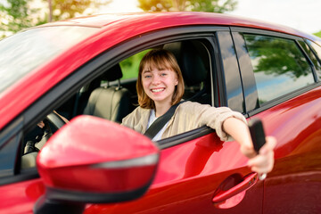 Fototapeta na wymiar Happy teen girl driving a new car on sunset