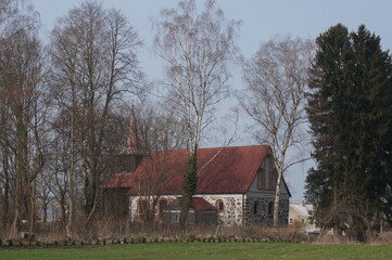 St. John the Baptist Church (Kościół św. Jana Chrzciciela) behind the trees. Sielsko (village in Lobez County), Poland.