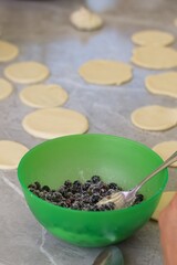 Blueberries for dumplings. Sprinkled with sugar. Next to the rolled out dough. Close-up.