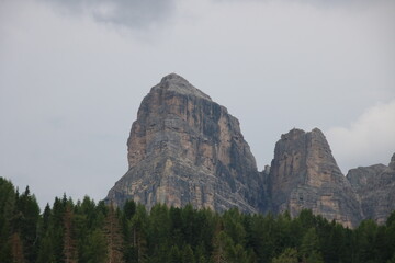 Rock formation with trees in foreground and a cloudy sky