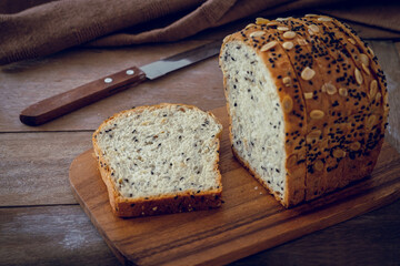 Whole grain bread slices on wooden board