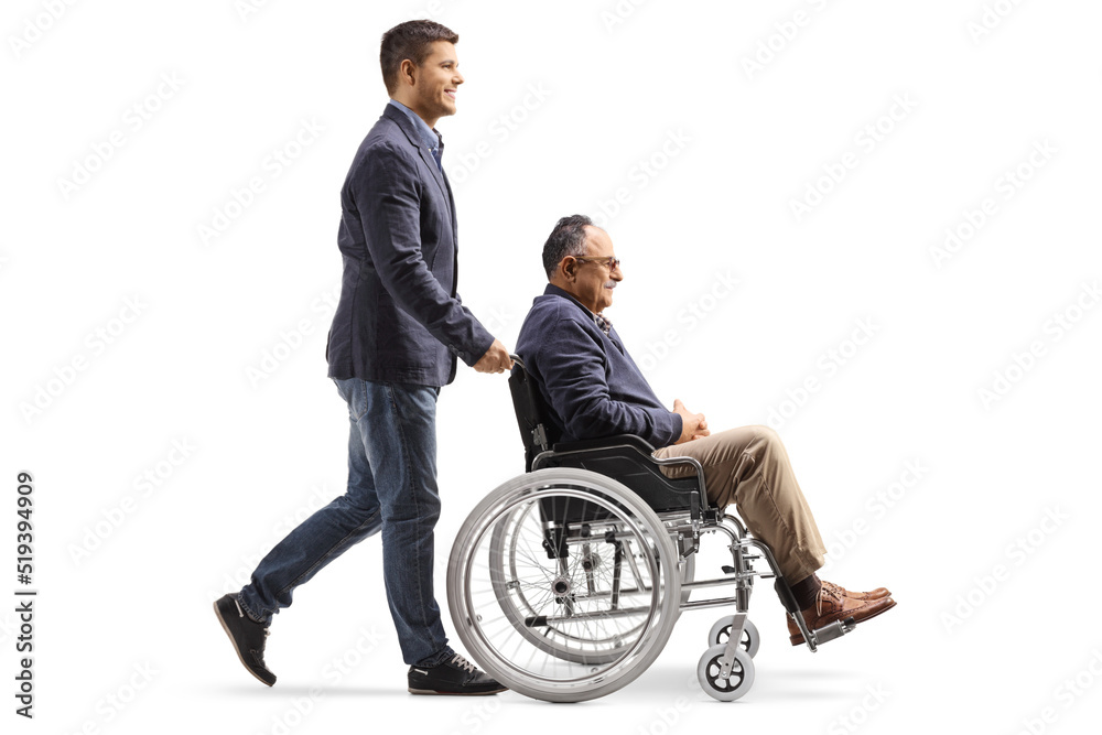 Sticker Full length profile shot of a son walking and pushing a mature man in a wheelchair