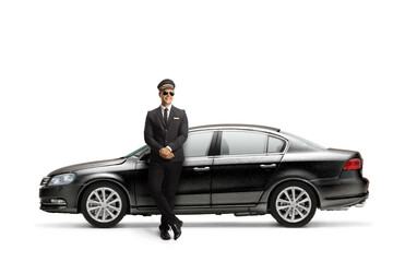 Young male professional chauffeur leaning on a black car
