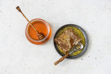 Obraz na płótnie Canvas Sweet honey in the comb and glass jar. 