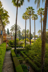 Beautiful formal public garden inside Alcazar Seville palace in summertime in Andalusia
