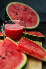 Delicious watermelon  outdoors wooden  table, GREEN  natural background sunny day, Heap,  Fresh ripe red, leaf, summer sunny garden juice drink organic sweet fruit, vegan food Tasty sliced board plate