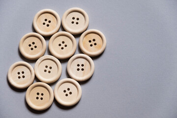 large wooden buttons on a gray background, free space. Sewing. Sewing materials. Clothing repair