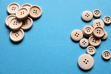 Wooden buttons on a blue background. Sewing. Place for text.