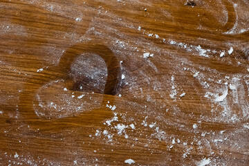 small heart made of flour on a wooden table. Love for cooking