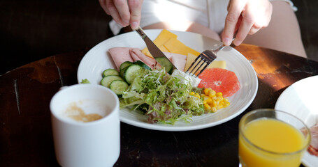 Woman have a breakfast in hotel, eating feta cheese