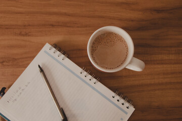 flat layer wooden table with notebook and coffee cup