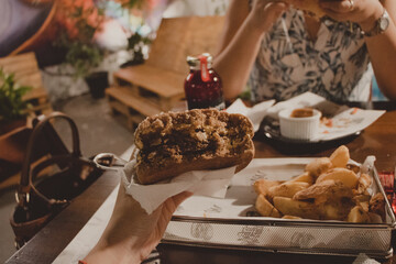 holding a bitten hamburger on the restaurant
