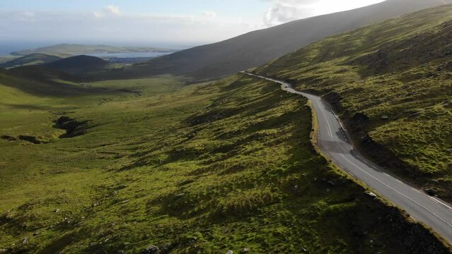 Green Majesty: Aerial Drone View of Serpentine Road Amidst Ireland's Dingle Mountains, Kerry