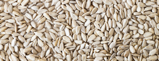 Top view of a pile of natural organic sunflower seeds isolated on white background.