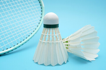 Fototapeta na wymiar Badminton shuttlecock and badminton racket on blue background