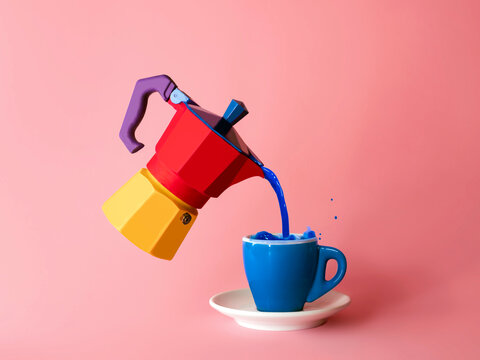 Blue liquid being poured into a cup from a multi coloured moka pot