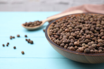 Peppercorns on light blue wooden table, closeup