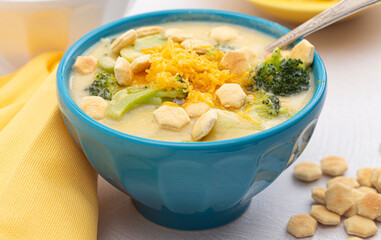 Cheddar Cheese and Broccoli Soup with Oyster Crackers on a White Kitchen Counter
