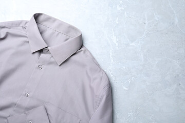 Stylish shirt on grey marble table, top view with space for text. Dry-cleaning service