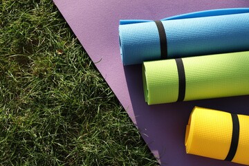 Bright exercise mats on fresh green grass outdoors, above view