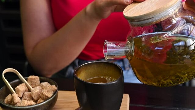 Woman pouring green tea at a japanese restaurant