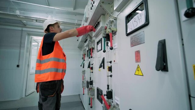 Electrical engineer working check the electric current voltage and overload at front of load center cabinet or consumer unit for maintenance in main power distribution system room.