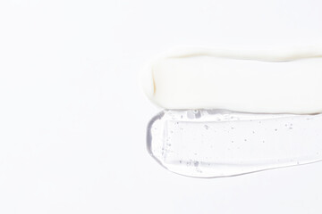 White cosmetic face cream or body lotion moisturizer strokes on white background. Hygiene, skincare product with creamy and gel texture. Beauty face creme smear swatch