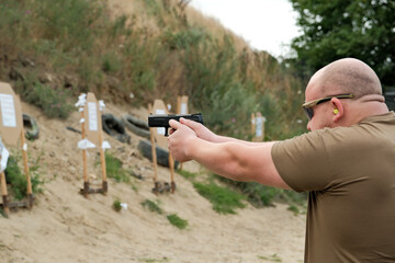 a man holds a gun in his hands. pistol shooting exercises