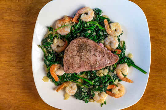 Season Tuna Steak  With Spinach Onions And Shrimp