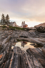 Pemaquid Point Lighthouse reflection at sunrise during on a summer morning in Bristol, Maine