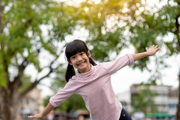 Asian little girl enjoys playing in a children playground, Outdoor portrait